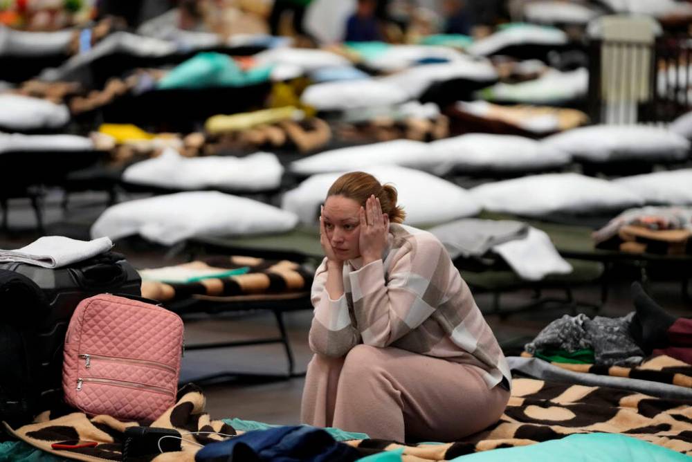(AP Photo/Markus Schreiber, File)
A woman puts her head in her hands as she sits in a refugee shelter set up inside a school gymnasium in Przemysl, Poland, on March 8. Around 2.5 million people have fled Ukraine in the two weeks since Russia invaded.