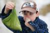JOHN WOODS / WINNIPEG FREE PRESS Jake Hultin carries a bag of his puppy Mauiճ poop as they go for a walk Tuesday, March 22, 2022. Nine year old Hutlin wrote a letter to the city after he noticed that Charleswood is lacking garbage cans for him to drop his doggie bags and litter while out for a walk. Hutlin is asking the city to put out more garbage cans. Re: Joyanne