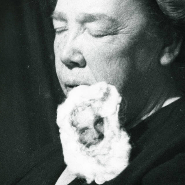 A photograph of the medium, Mary Marshall, with a teleplasmic mass attached to her mouth featuring a partial materialization of a miniature version of the face of the spirit, Walter, during a seance at the home of Sylvia Barber in 1951. (University of Manitoba Archives)