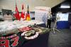 RCMP Cpl. David Portelance at the podium next to a large quantity of drugs, cash and outlaw motorcycle club patched clothing at RCMP D Division Headquarters, seized as part of Project Divergent. (Erik Pindera / Winnipeg Free Press)