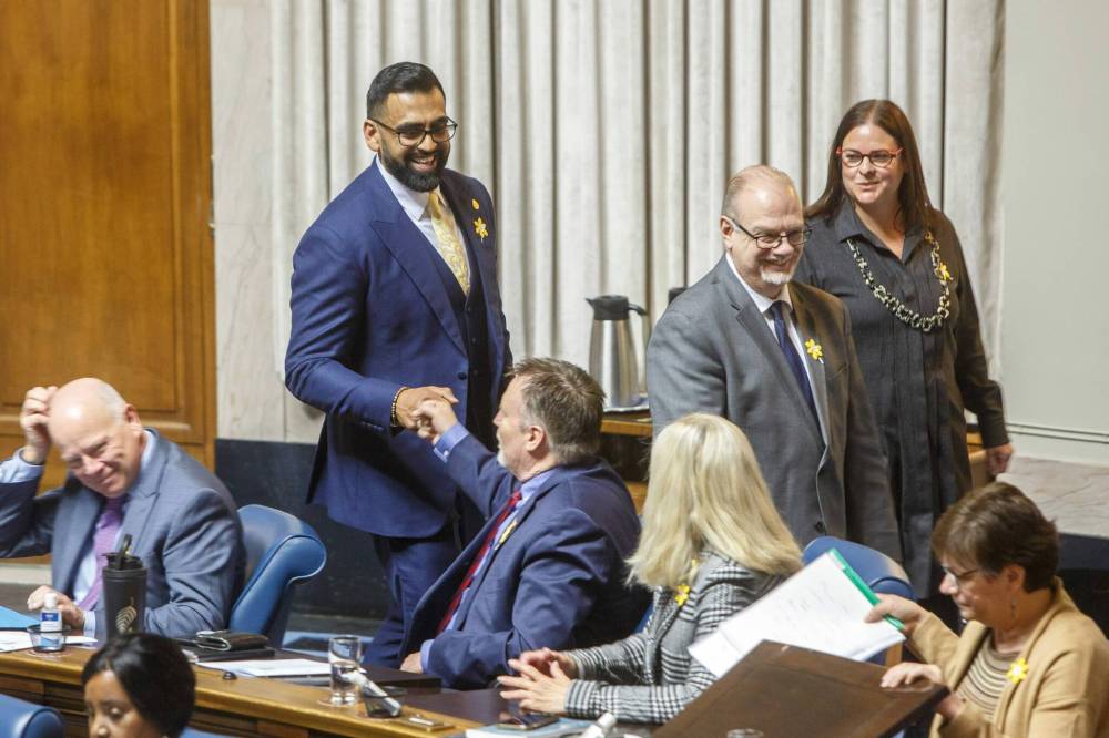 Fort Whyte MLA Obby Khan is greeted by his colleagues as he enters the chamber at the Manitoba Legislative Building on Monday. (Mike Deal / Winnipeg Free Press)