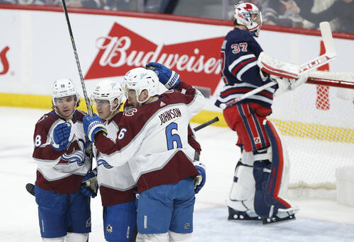 Colorado Avalanche’s Alex Newhook (18), Nicolas Aube-Kubel (16) and Erik Johnson (6) celebrate Aube-Kubel’s goal against Winnipeg Jets goaltender Connor Hellebuyck during the first period in Winnipeg, Friday. THE CANADIAN PRESS/John Woods
