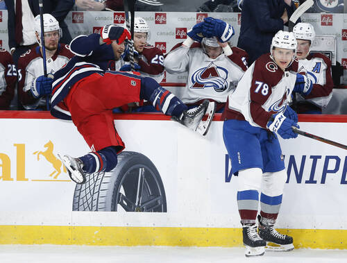 Winnipeg Jets’ Mark Scheifele gets checked by Colorado Avalanche’s Nico Sturm during the second period. THE CANADIAN PRESS/John Woods