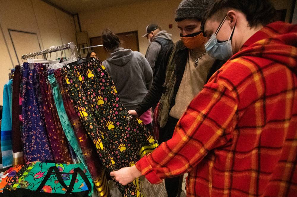 Sav Jonsa and Pheonix Hourie examine some clothes with colourful prints. (Daniel Crump / Winnipeg Free Press)