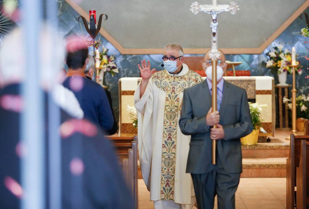 JOHN WOODS / WINNIPEG FREE PRESS 
Father Sam Argenziano greets his parishioners as they participate in Easter mass at Holy Rosary Church on River Avenue on Easter Sunday.