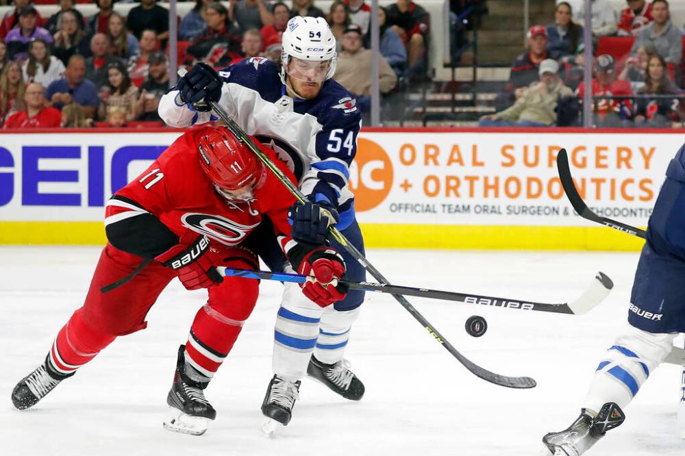 Carolina Hurricanes’ Jordan Staal battles with Winnipeg Jets’ Dylan Samberg during the second period. (AP Photo/Karl B DeBlaker)