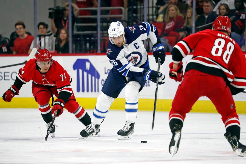 Winnipeg Jets’ Blake Wheeler controls the puck between Carolina Hurricanes’ Seth Jarvis and Martin Necas during the first period. (AP Photo/Karl B DeBlaker)