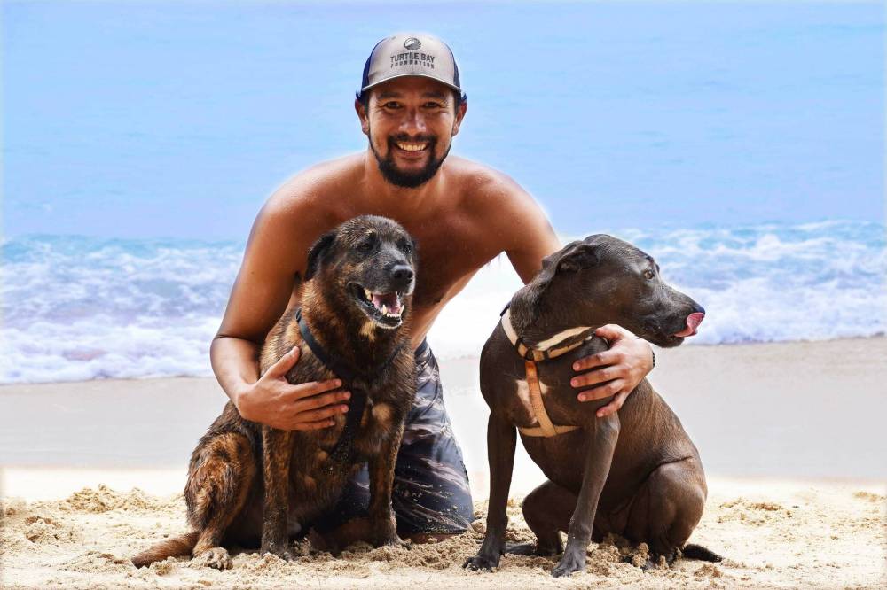 Rocky Canon of Hawaii Surf Dogs with his business partners Kahuna, left, and Hina.