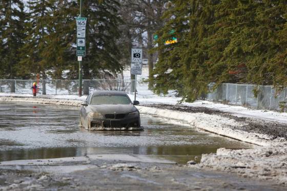 MIKE DEAL / WINNIPEG FREE PRESS An abandoned vehicle in the middle of an impassable River Road just north of Bishop Grandin Boulevard.