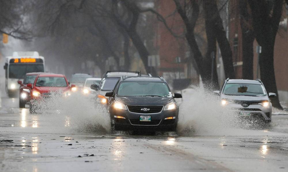 JOHN WOODS / WINNIPEG FREE PRESS FILES
Cars drive through water on Sherbrook St. last Sunday. Forecasters are estimating another Colorado low could bring up to 40 millimetres of rain to parts of Manitoba this weekend.