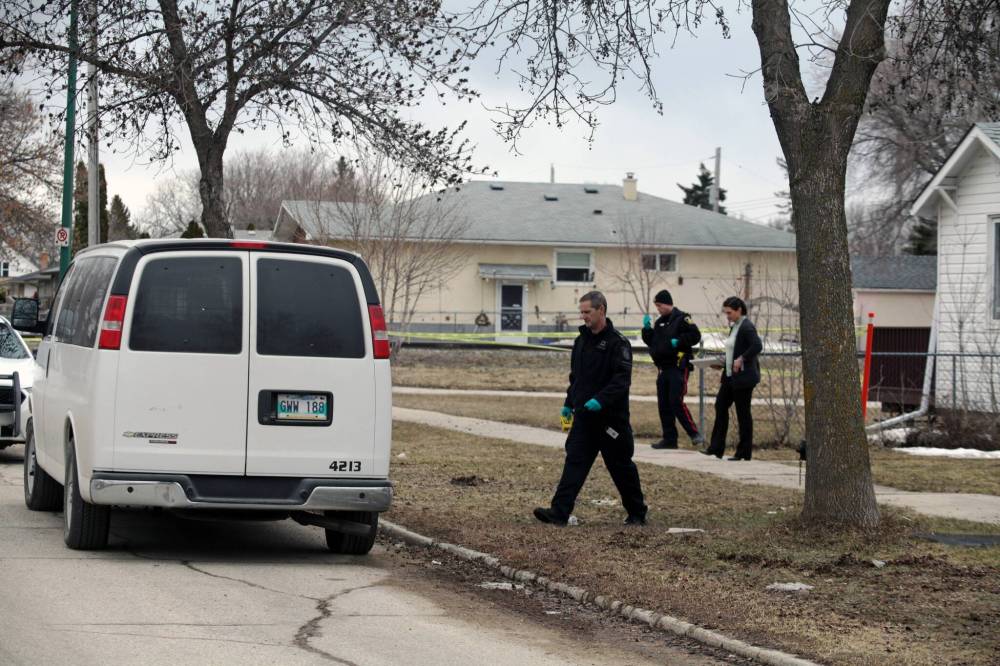 ERIK PINDERA / WINNIPEG FREE PRESS
A forensics investigator, a uniformed officer and a plainclothes officer outside of a home on the 900 block of Manitoba Avenue, where neighbours said a body was found Thursday.