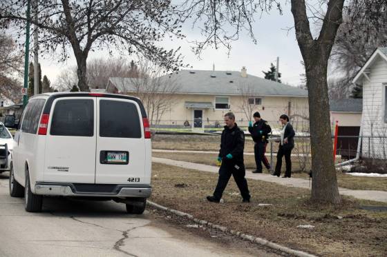 ERIK PINDERA / WINNIPEG FREE PRESSA forensics investigator, a uniformed officer and a plainclothes officer outside of a home on the 900 block of Manitoba Avenue, where neighbours said a body was found Thursday.