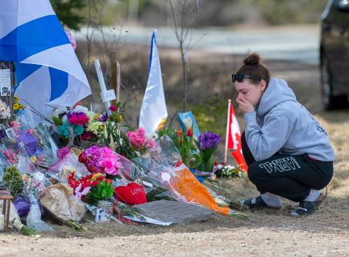 Andrew Vaughan / The Canadian Press files
In this 2020 photo, a woman pays her respects at a roadside memorial in Portapique, N.S. after a shooting rampage that left 22 people dead.