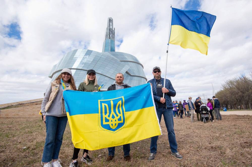MIKE SUDOMA / WINNIPEG FREE PRESS
(Left to Right) Kateryna, Nadia, Dmytro Semenyshyn and Sergii Prytuliak hold up A Ukrainian Flag in front of the CMHR after a march from Ukraine event Sunday afternoon.