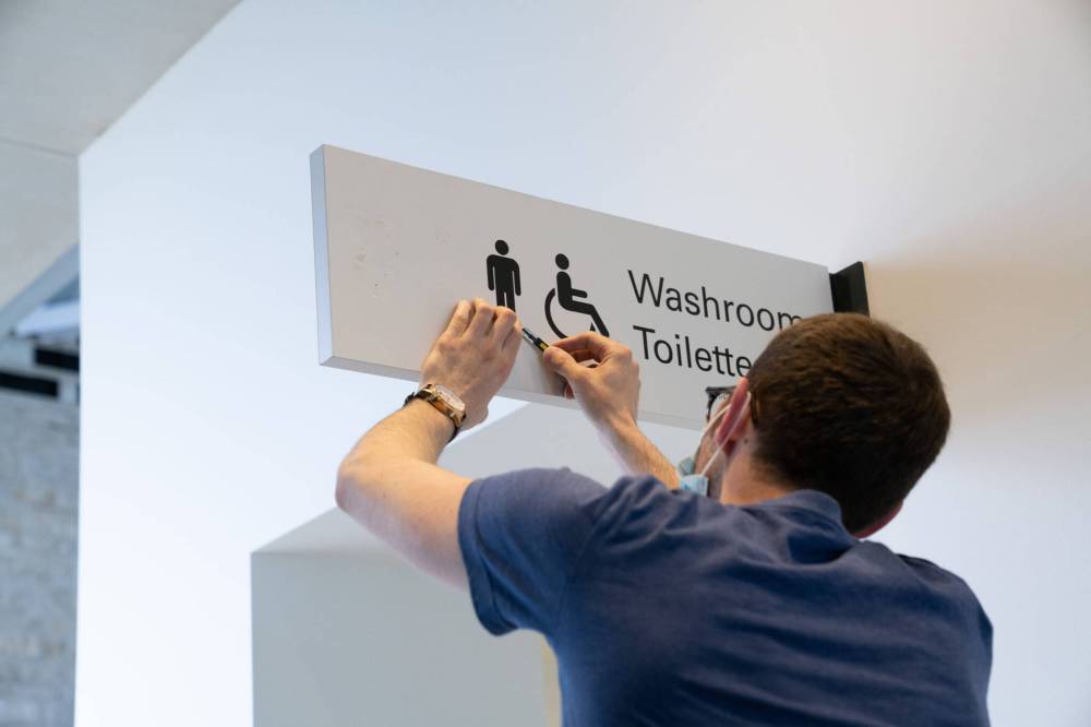Jessica Sigurdson / CMHR
Wes Waagenaar, a sign installer with SignEX, removes gender-specific decals at the Canadian Museum for Human Rights, which is converting all its bathrooms to gender-inclusive spaces.