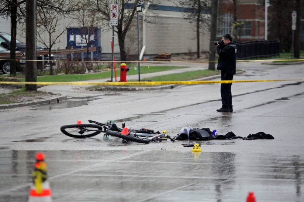 ERIK PINDERA/WINNIPEG FREE PRESS A Winnipeg Police Service forensics officer photographs the scene the intersection of Erin Street and Sargent Avenue, where a cyclist was critically injured in an apparent hit-and-run Wednesday morning.