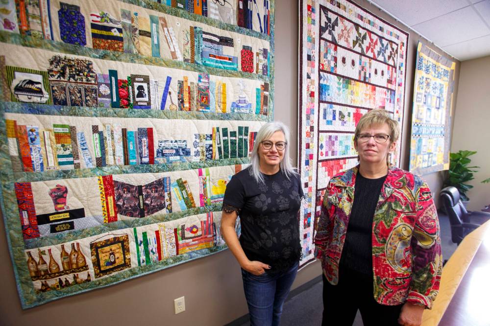Jennifer Wiebe (left) and Heather Stone at the North Norfolk-MacGregor Regional Library where five of their quilts are on display. (Mike Deal / Winnipeg Free Press)