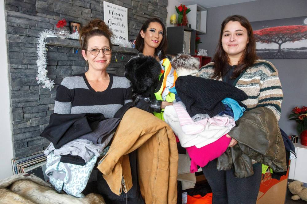MIKE DEAL / WINNIPEG FREE PRESS
Theresa Chanowski (left), her daughter Katie Titanich (right) and best friend Jessica Nguyen-Yeryk (centre) with clothing and winter jackets that have been donated. The group is distributing hot meals and winter wear to people on the streets in Winnipeg’s inner city by collecting donations from family and friends.
