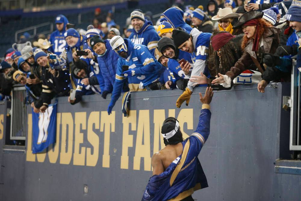 Rasheed Bailey and the Winnipeg Blue Bombers celebrate with fans IG Field in Winnipeg on Wednesday. THE CANADIAN PRESS/John Woods
