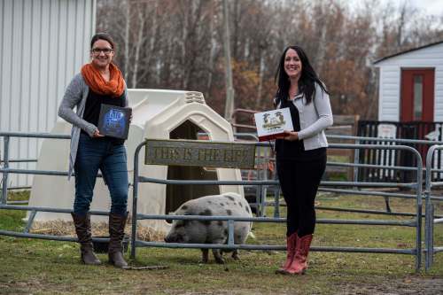SUPPLIED PHOTO
Lucy Sloan (right) and her colleague Joanne Lariviere pose with Wilbert the pig, a resident of Lil&rsquo; Steps Miniature and Wellness Farm and a character in Sloan&rsquo;s children&rsquo;s book Cindy and Christabelle&rsquo;s Big Scare.