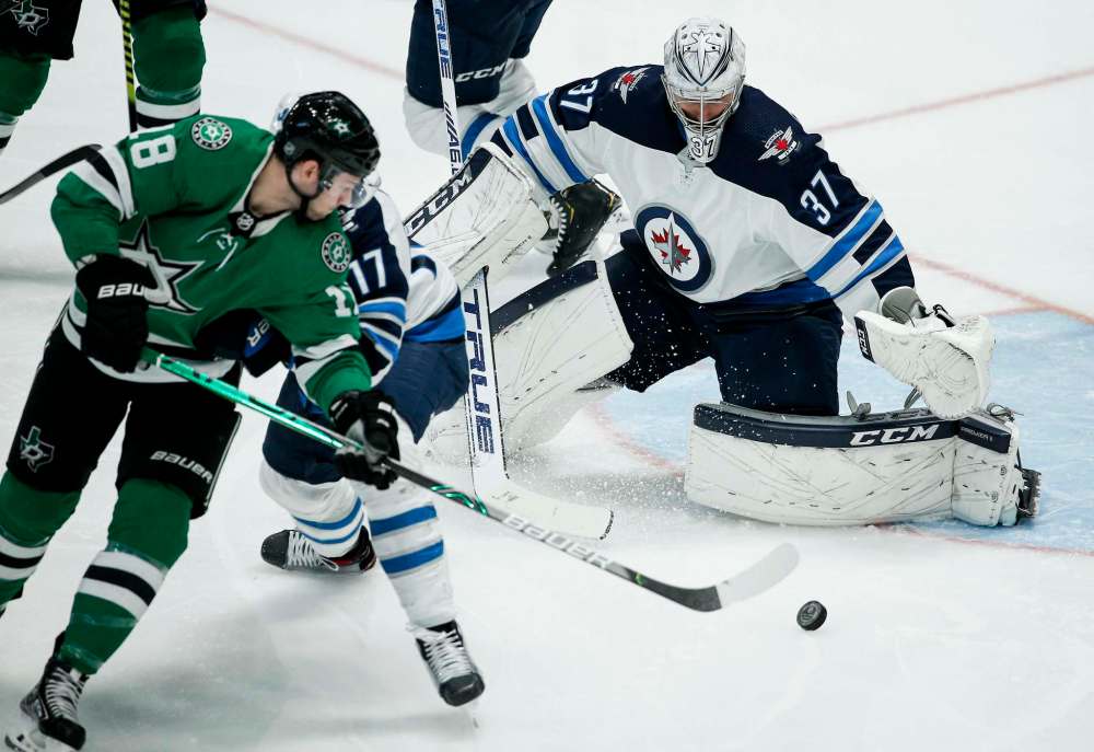 (AP Photo/Brandon Wade)
Dallas Stars forward Jason Dickinson attempts a backhand shot as Winnipeg Jets goaltender Connor Hellebuyck defends the net during the second period Thursday in Dallas.