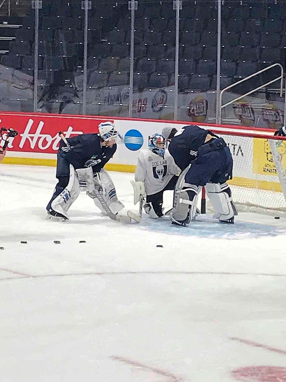 Kylan Jackson (centre) gets tips from Laurent Brossoit (left) and Connor Hellebuyck during Saturday's Dream Factory event at Bell MTS Place. (Jason Bell/Winnipeg Free Press)