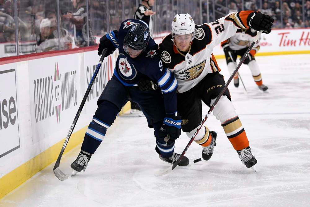 Fred Greenslade / The Canadian Press
Winnipeg Jets' Andrew Copp and Anaheim Ducks' Carter Rowney battle along the boards for the puck on Sunday.