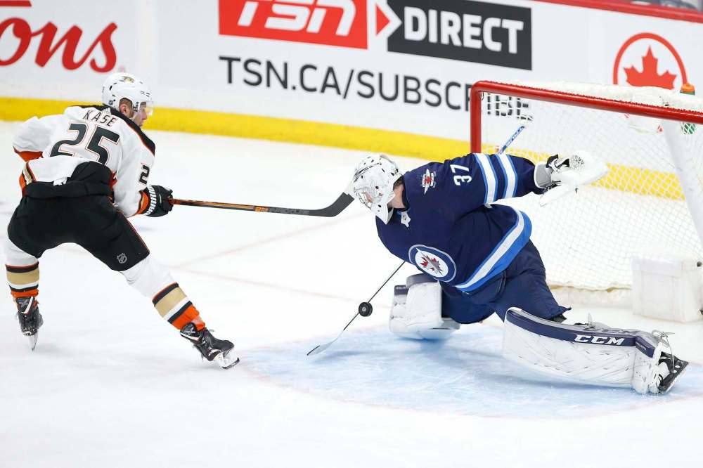 Winnipeg Jets goaltender Connor Hellebuyck (37) stops the shot by Anaheim Ducks' Ondrej Kase (25) during the second period. (John Woods / Winnipeg Free Press)