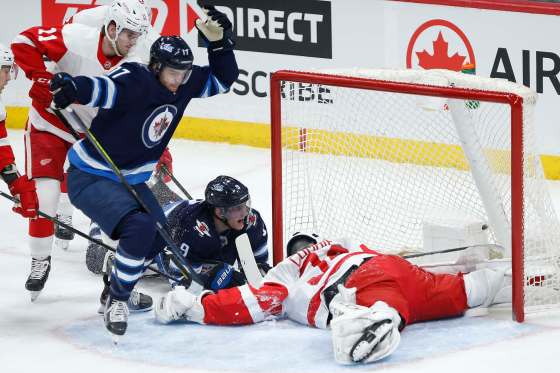 Adam Lowry celebrates after banging the partially smothered puck across the red line Tuesday against Detroit. (John Woods / Winnipeg Free Press)