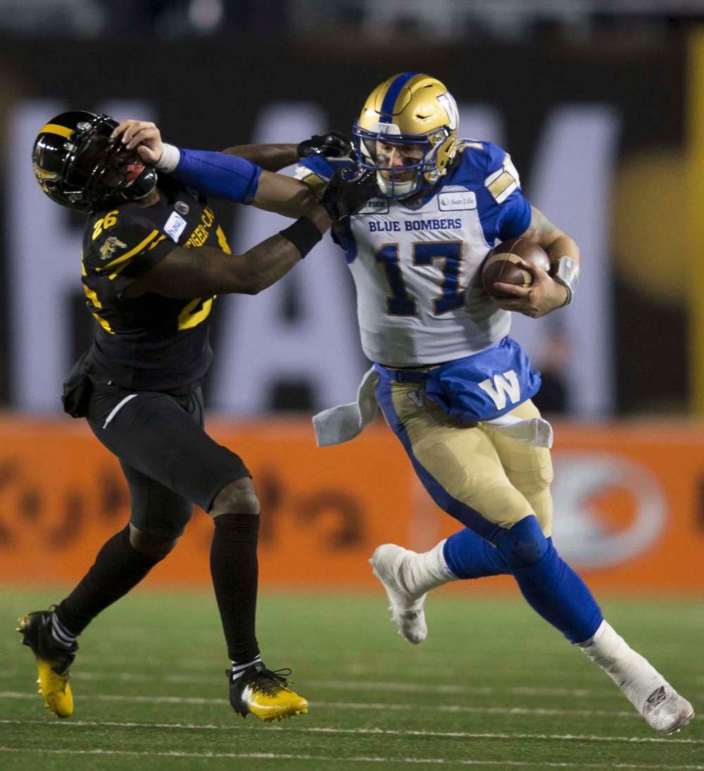 Todd Korol / The Canadian Press files
Winnipeg general manager Kyle Walters calls quarterback Chris Streveler (right, stiff-arming Hamilton’s Cariel Brooks in the Grey Cup) ‘a very unique individual.’