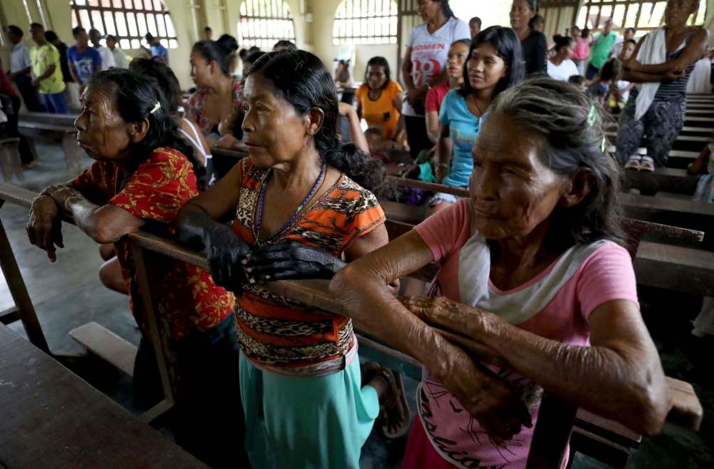 Fernando Vergara / The Associated Press files
Indigenous Tikuna women attend Catholic mass in Nazareth, Colombia. Catholic villagers say the community only gets visited by priests on special occasions and that having someone who could perform sacraments on a regular basis would revitalize the Catholic faith.