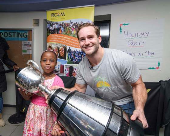 Mike Sudoma / Winnipeg Free PressSharif Atom poses with the Grey Cup and Winnipeg Blue Bombers Linebacker, Thomas Miles at the Immigrant and Refugee Community Organization of Manitoba Thursday.