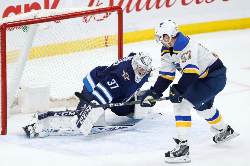 JOHN WOODS / THE CANADIAN PRESS FILES
St. Louis Blues forward David Perron scores the game-winning goal in overtime against Jets goaltender Connor Hellebuyck at Bell MTS Place on Friday.