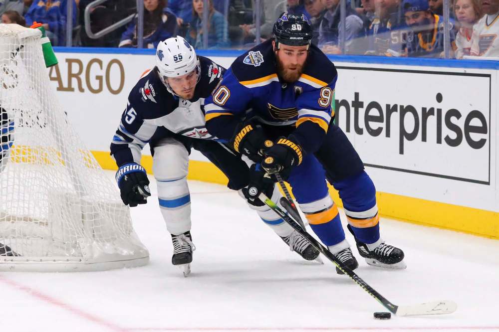 Winnipeg Jets Mark Scheifele (55) pokes the puck away from St. Louis Blues centre Ryan O'Reilly (90) during the second period of an NHL hockey game Sunday in St. Louis. (Dilip Vishwanat / The Associated Press)