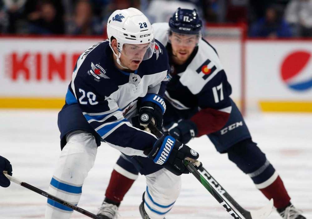 David Zalubowski / The Associated Press
Winnipeg Jets centre Jack Roslovic, front, wins a race to the puck in front of Colorado Avalanche centre Tyson Jost during the second period on Tuesday, in Denver.