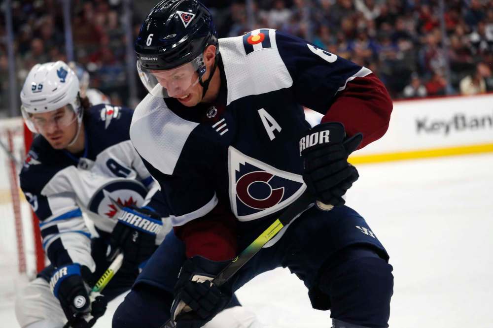 David Zalubowski / The Associated Press
Colorado Avalanche defenceman Erik Johnson, front, fights for control of the puck in the corner with Winnipeg Jets centre Mark Scheifele.