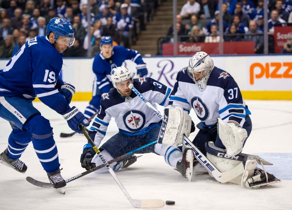 THE CANADIAN PRESS/Frank Gunn
Toronto Maple Leafs' Jason Spezza shoots on Winnipeg Jets goaltender Connor Hellebuyck in Toronto on Wednesday. How are the Jets winning so often when they are so bad according to advance analytics?