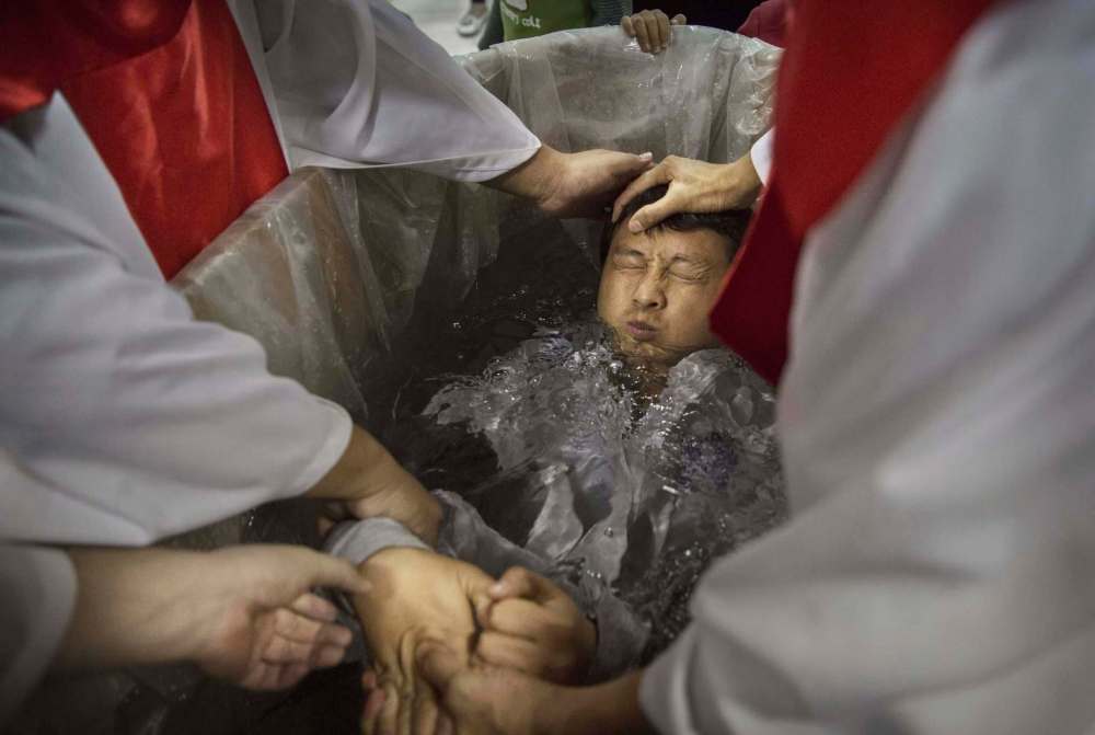 Kevin Frayer / Getty Images
A man is baptized at an underground church in Beijing. China places restrictions on Christians and allows legal practice of the faith only at state-approved churches.