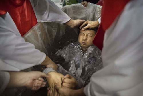 Kevin Frayer / Getty Images
A man is baptized at an underground church in Beijing. China places restrictions on Christians and allows legal practice of the faith only at state-approved churches.