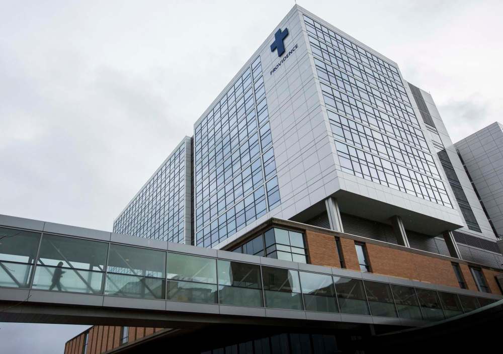 A person walks across the skybridge at Providence Regional Medical Center Everett where a man with the first case of Wuhan coronavirus in the United States is being treated on Tuesday, Jan. 21, 2020, in Everett, Wash. A U.S. resident who recently returned from a trip to central China has been diagnosed with the new virus. Health officials said Tuesday that the man returned to the Seattle area in the middle of last week after traveling to the Wuhan area, where the outbreak began. (Olivia Vanni/The Herald via AP)