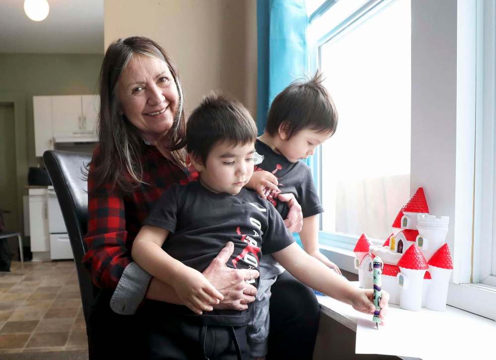 Hill gives her great-grandkids a hug, Jace, 1, and James, 3, at the opening of Granny's House Wednesday. (Ruth Bonneville / Winnipeg Free Press)