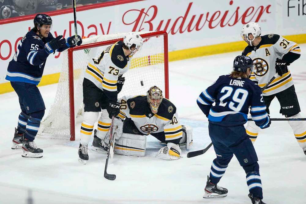 During his 500th game Friday night, Winnipeg Jets' Mark Scheifele (55) celebrated as Patrik Laine (29) scored on Boston Bruins goaltender Tuukka Rask (40) as Charlie McAvoy (73) and Patrice Bergeron (37) defend. (John Woods / The Canadian Press)