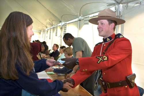 In this 2008 photo, Saskatoon RCMP officer David Kisters hands out the annual five dollar annuity still given to treaty members. Some consider the practice a slap in the face, while others see it as a symbolic gesture. (Gord Waldner / The Canadian Press files)