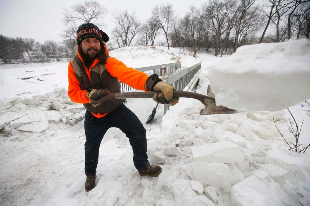 JOHN WOODS / WINNIPEG FREE PRESS FILES
Brad Hignell, pictured, and Wolseley resident Chris Beauvilain shovelled the snow and ice from the Omand’s Creek bridge after the city closed it to pedestrians in December.