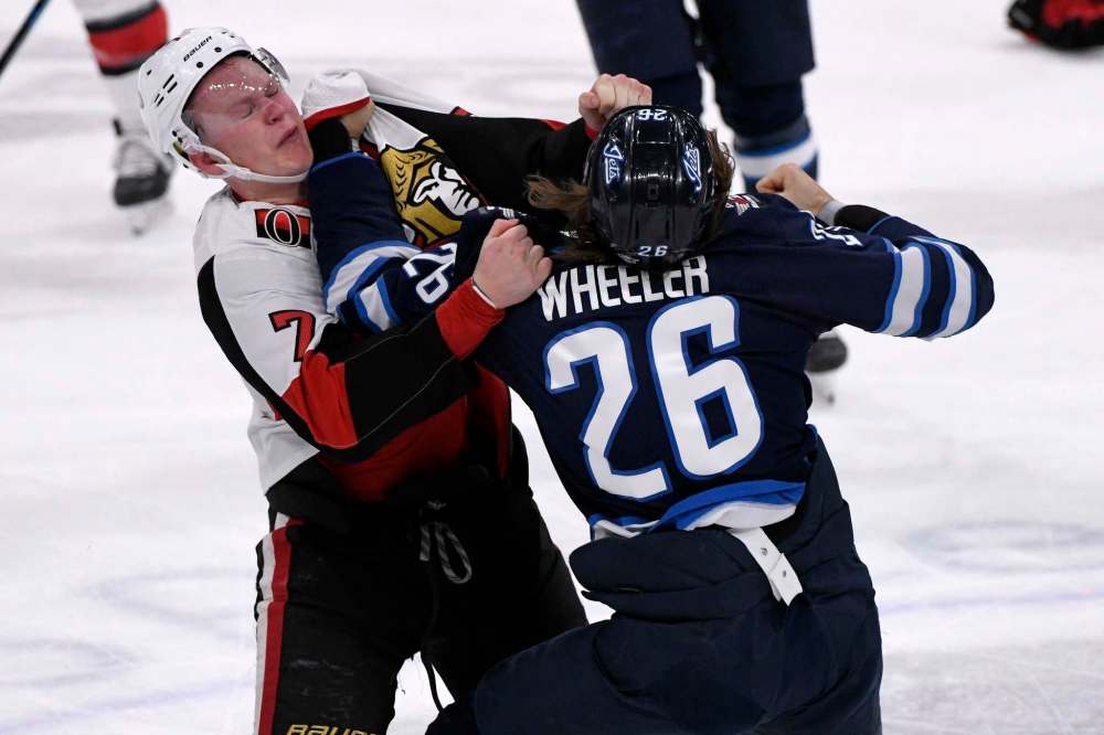 Winnipeg Jets' Blake Wheeler (26) fights Ottawa Senators' Brady Tkachuk (7) during first period. (Fred Greenslade/The Canadian Press)