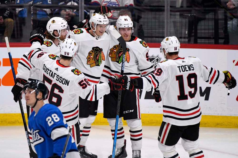 Fred Greenslade / The Canadian Press
Chicago Blackhawks’ Dominik Kubalik (centre) celebrates his goal against the Winnipeg Jets, which was aided by a landmark assist from Jonathan Toews (19).