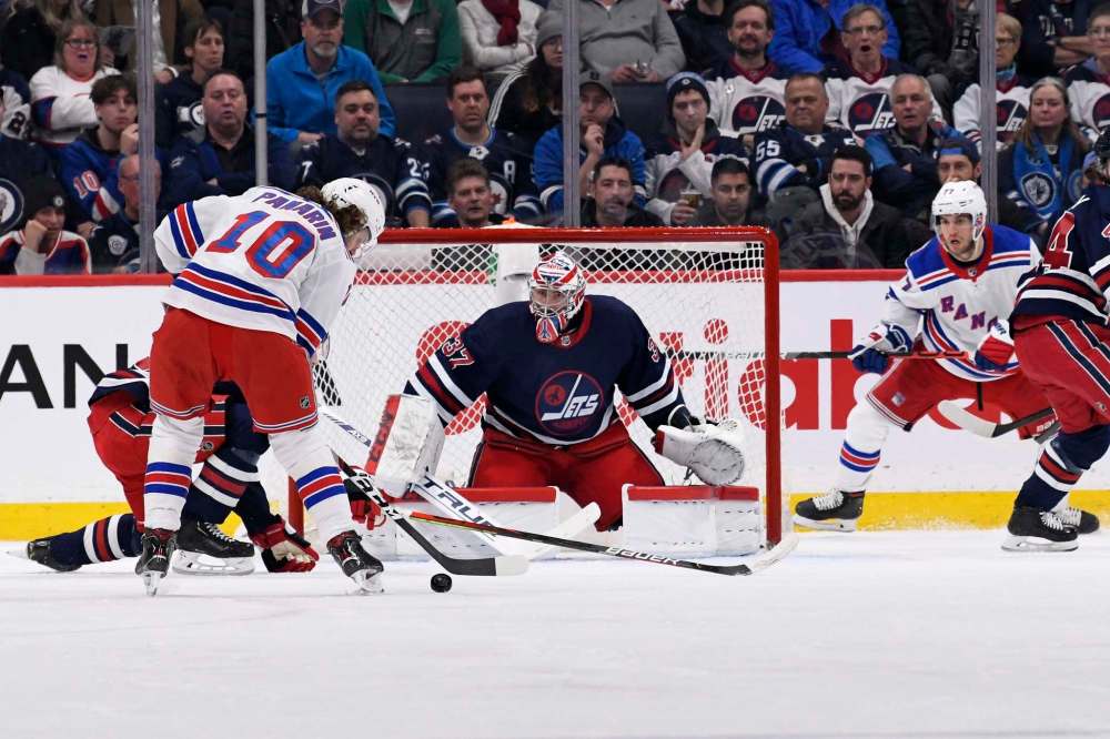 THE CANADIAN PRESS/Fred Greenslade
Winnipeg Jets goaltender Connor Hellebuyck keeps his eye on the puck as New York Rangers' Artemi Panarin prepares to take a shot during the second period in Winnipeg on Tuesday.