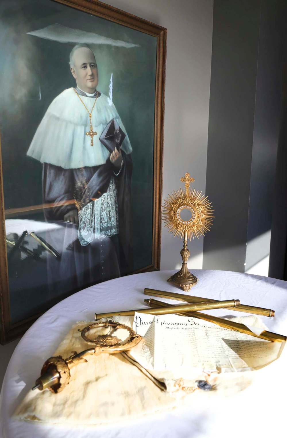 Papal documents with a metal seal giving a new designation to Archbishop Sinnott (painting on the wall) in 1952.