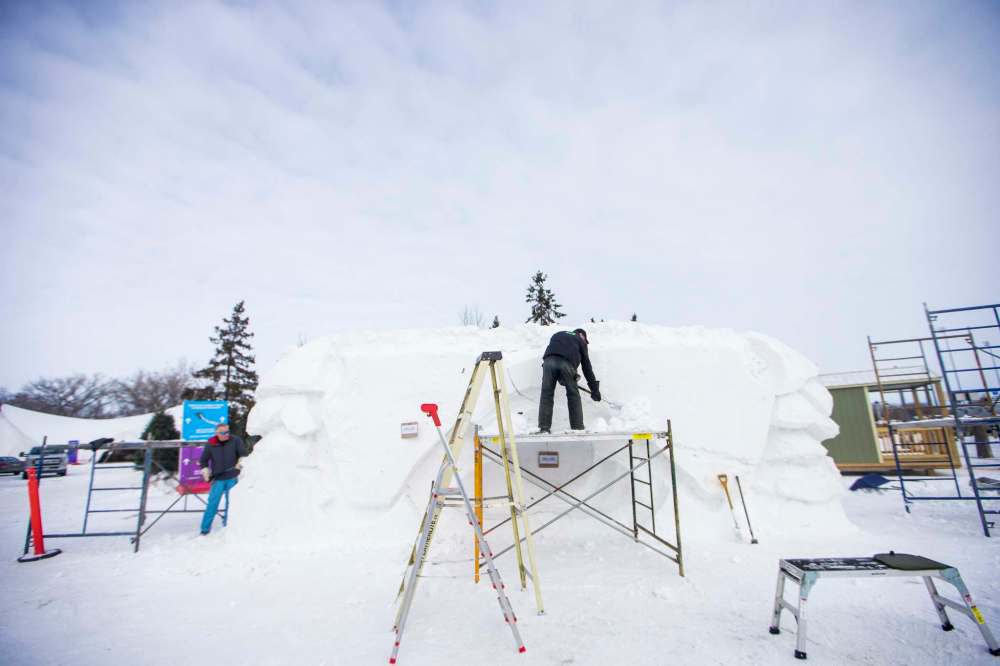 Jaccques Boulet (left) and David MacNair work on an owl as part of the Festival du Voyageur's snow sculpting contest. (Mikaela MacKenzie / Winnipeg Free Press)