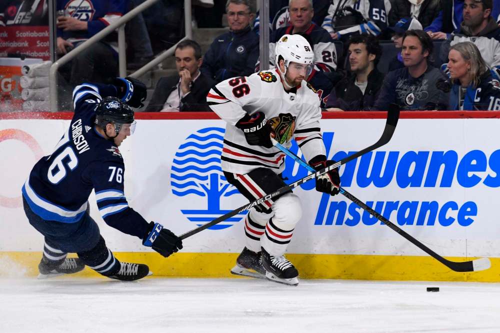 Fred Greenslade
/ The Canadian Press
Chicago Blackhawks' Erik Gustafsson (56) skates away from Winnipeg Jets' Andrei Chibisov (76) during second period NHL action in Winnipeg on Sunday, Feb. 16, 2020.